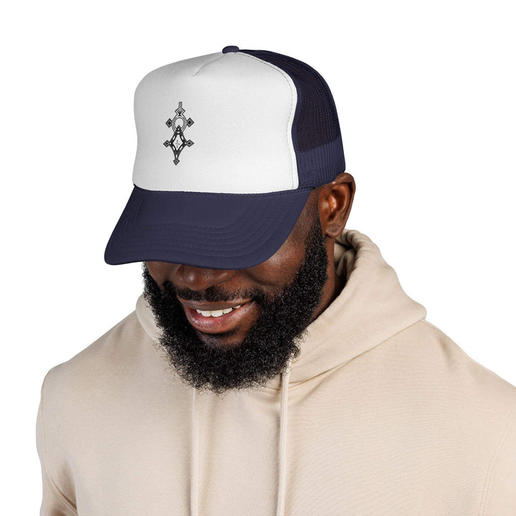 Man wearing a navy and white trucker cap with adjustable snapback and embroidered front logo