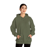 Woman wearing olive green Heavy Blend™ hooded sweatshirt with kangaroo pocket and drawstring hood