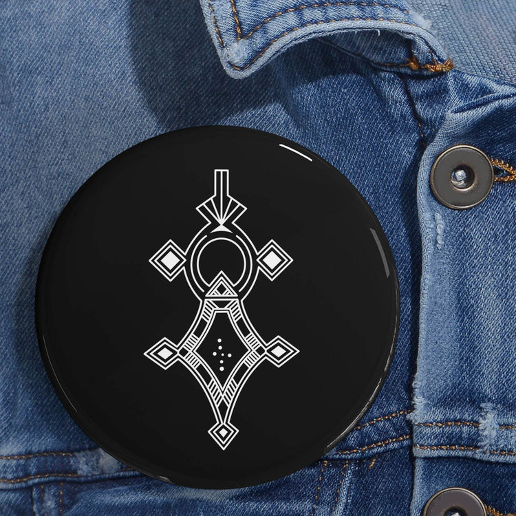 Round pin with black background and white geometric design on denim jacket, steel shell, magnetic backing, UV protective cover