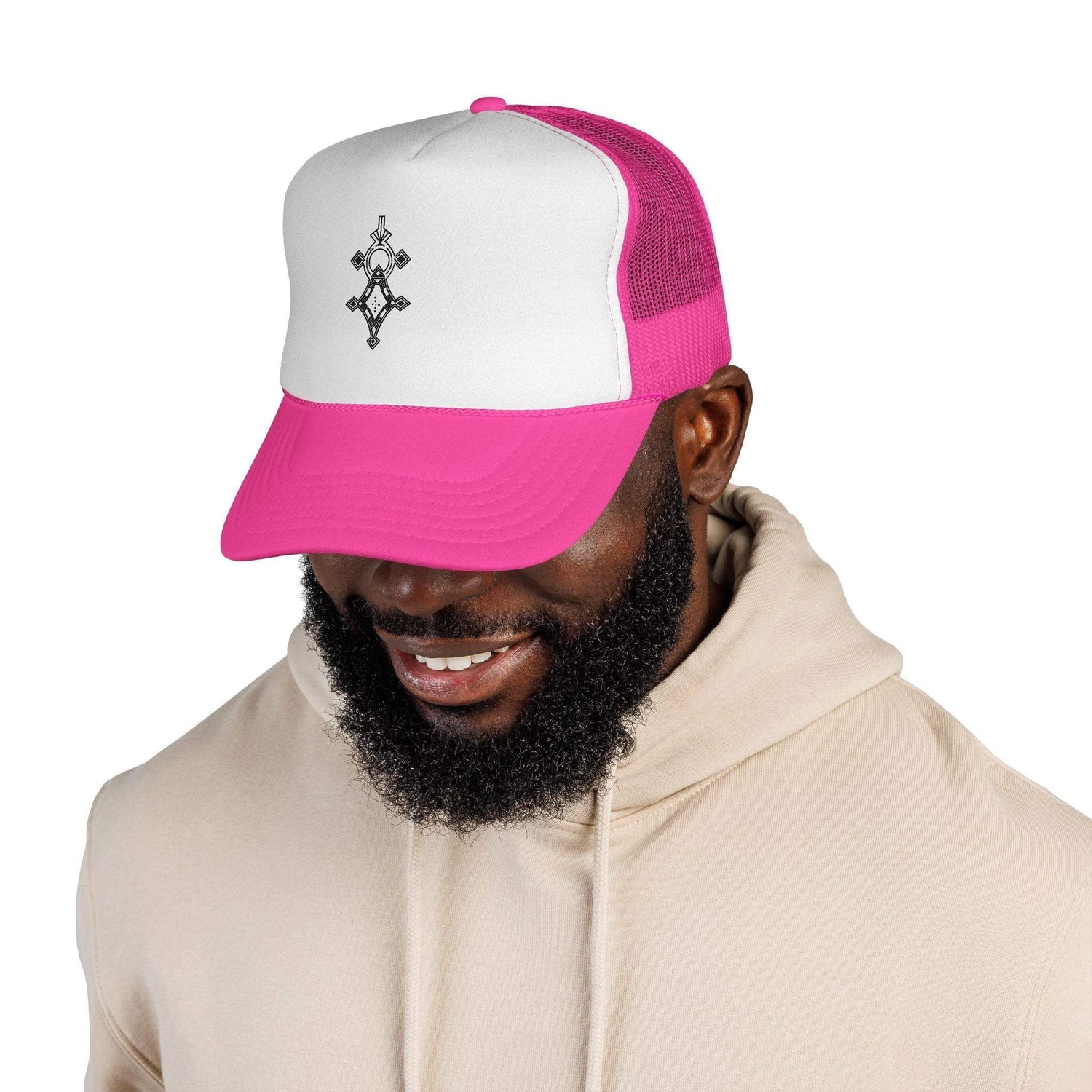 Man wearing pink and white trucker cap with black emblem on front and beige hoodie