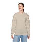 Women Heavy Blend™ Crewneck Sweatshirt in beige, medium-heavy cotton-polyester blend, classic fit with ribbed collar and durability stitching, modeled by woman in casual jeans