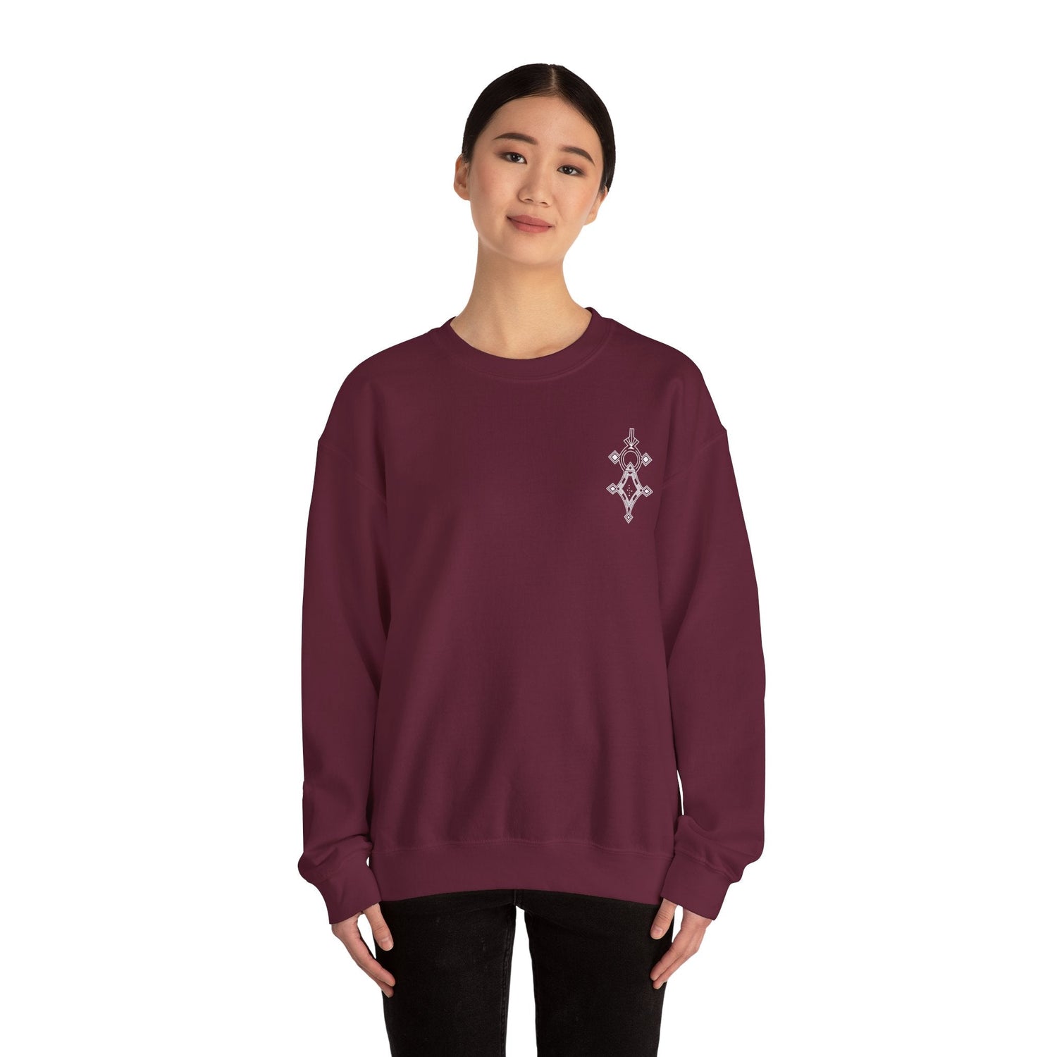 Woman wearing maroon Heavy Blend™ crewneck sweatshirt with embroidery on chest, made of cotton and polyester blend.