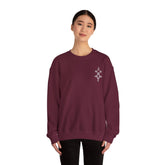 Woman wearing maroon Heavy Blend™ crewneck sweatshirt with embroidery on chest, made of cotton and polyester blend.