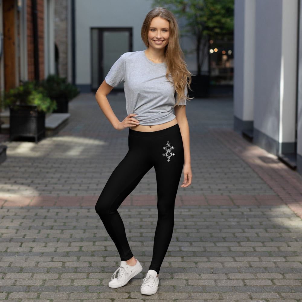 woman wearing black polyester spandex leggings with decorative design and gray t-shirt outdoors