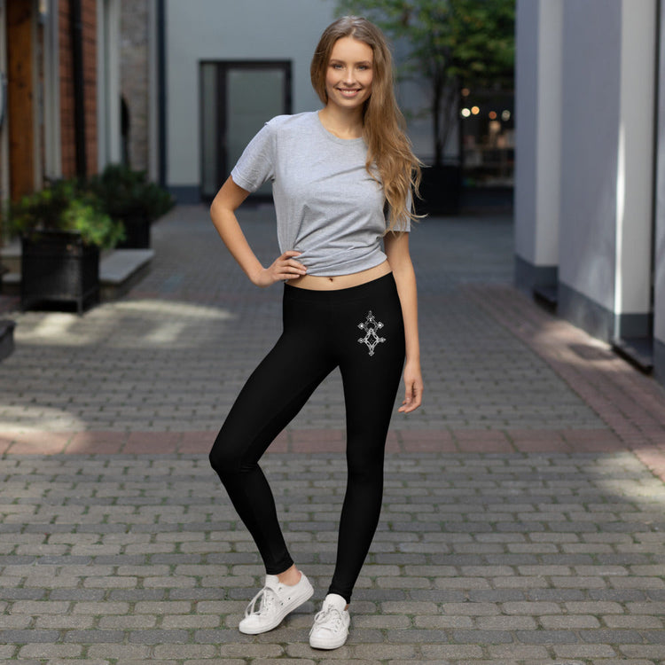 woman wearing black polyester spandex leggings with decorative design and gray t-shirt outdoors