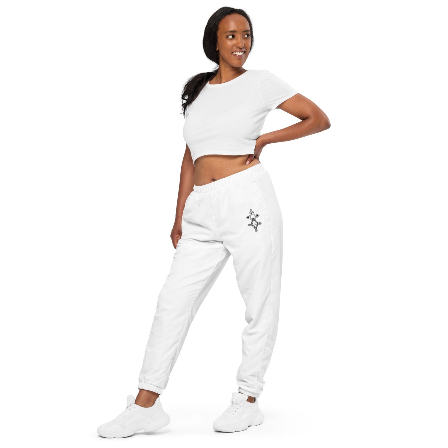 Woman wearing white lightweight water-resistant track pants with elastic waistband and cuffs showcasing streetwear style