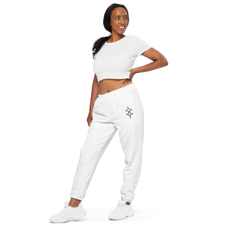 Woman wearing white lightweight water-resistant track pants with elastic waistband and cuffs showcasing streetwear style