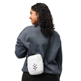 Woman wearing a white utility crossbody bag with adjustable strap and two spacious pockets over dark gray sweatshirt