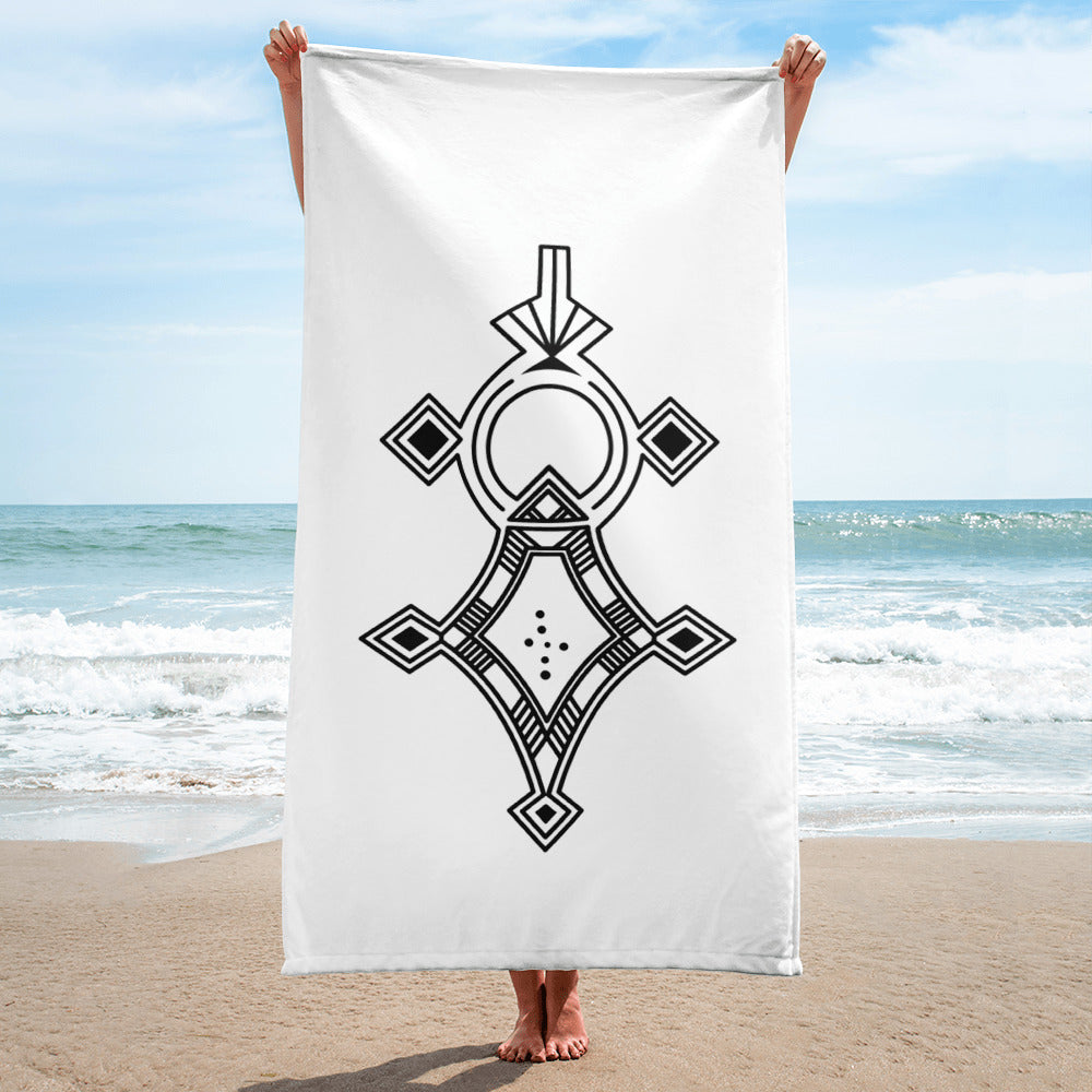White sublimation towel with black geometric design held on beach background