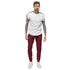 Man wearing maroon men fleece sweatpants with white sneakers and white t-shirt