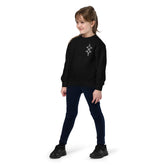 youth wearing black crewneck sweatshirt with geometric design, navy pants, and black sneakers