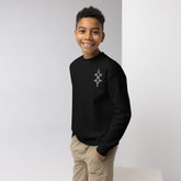 Youth crewneck sweatshirt in black with graphic design worn by smiling boy with hands in pockets