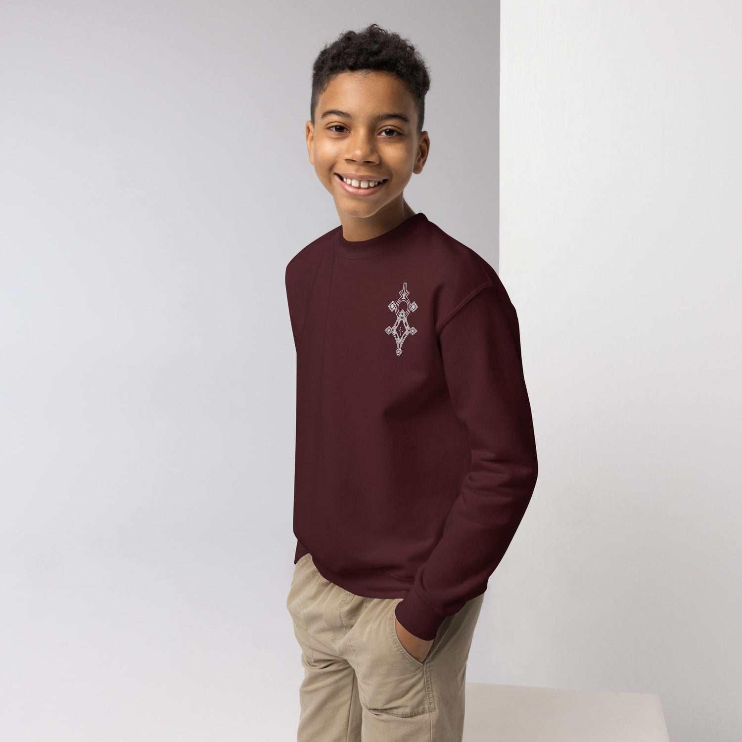 youth wearing maroon cozy crewneck sweatshirt with small chest design