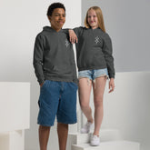 Teen boy and girl wearing dark gray youth heavy blend hoodies with front pouch pockets and no drawcords, styled for comfort and durability.
