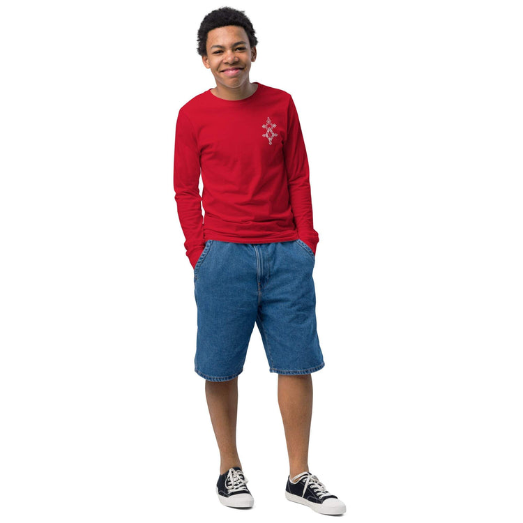 youth long sleeve tee in red cotton worn by boy with denim shorts and sneakers