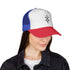 Woman wearing blue, white, and red trucker cap with mesh back and adjustable snap closure