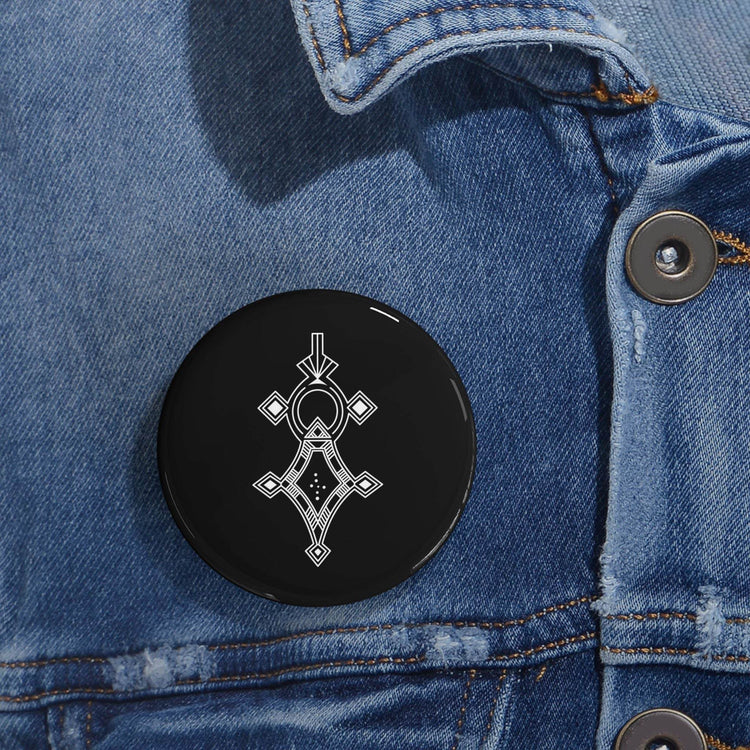 Round pin with geometric design on denim jacket, featuring steel shell and glossy finish