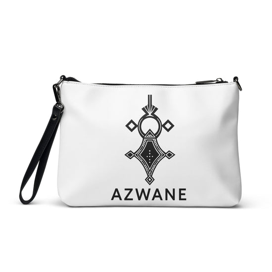 White faux leather crossbody bag with black geometric design, removable wrist strap, and zip-top closure.