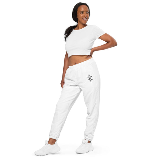 Woman wearing white lightweight water-resistant track pants with elastic waistband and cuffs showcasing streetwear style