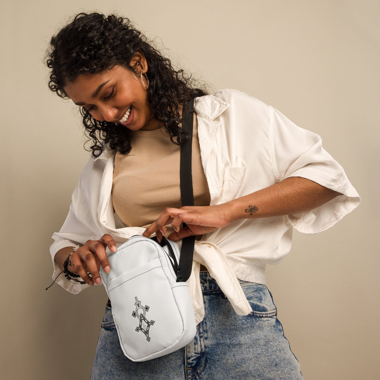 Sturdy white utility crossbody bag with adjustable strap and two spacious pockets worn by smiling woman