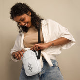 Sturdy white utility crossbody bag with adjustable strap and two spacious pockets worn by smiling woman