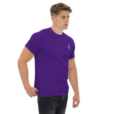 Man wearing purple classic tee with small chest design, paired with black jeans