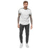 Man wearing charcoal heather men fleece sweatpants with white graphic tee and sneakers
